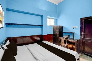 Une chambre avec un lit, un bureau, une chaise et une armoire.