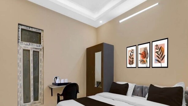 A hotel room with a large bed, a desk with a chair, a window, and three framed pictures on the wall. - Hotel O Singar Nagar Metro Station (Lucknow)