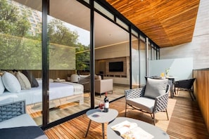Ein modernes Interieur mit einer großen Glaswand, einer Holzzieldecke und einer gemütlichen Sitzecke mit Tisch und Stühlen.