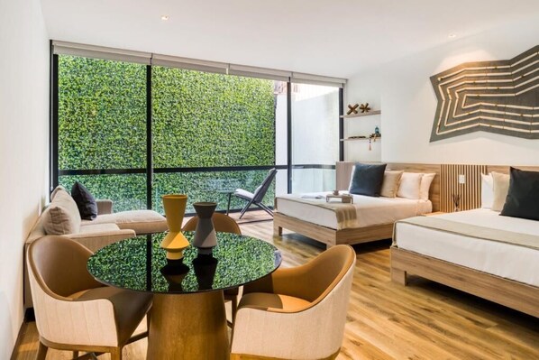 Una sala moderna con un ventanal grande, una mesa redonda, dos sofás y una obra de arte abstracto colgada en la pared.