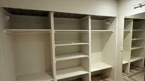 Ein Zimmer mit Einbauschrank, der mehrere Regale und eine spiegelnde Schranktür bietet.