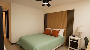 A hotel room with a bed, a nightstand, a desk, a ceiling fan, and a door.