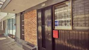 A building with a black door, a red mailbox, and a brick wall.
