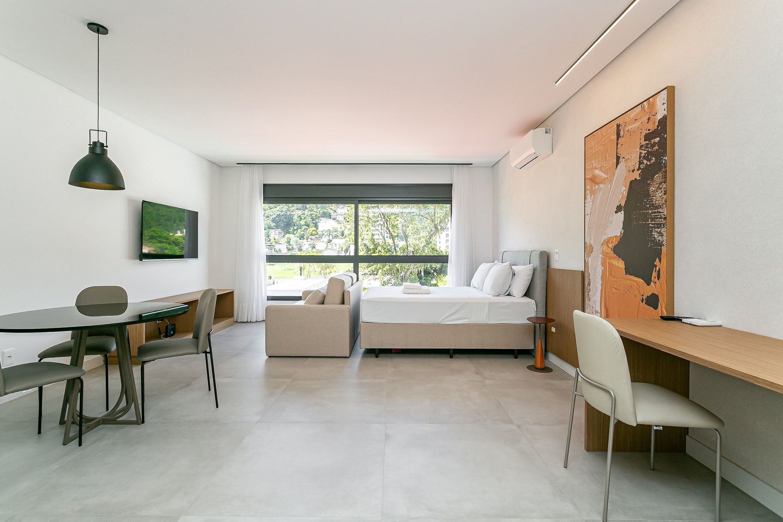A modern room with a bed, a desk, a sofa, and a dining table.
