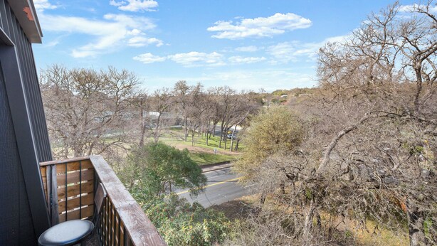Ein Balkon mit Blick auf einen Park und Bäume.