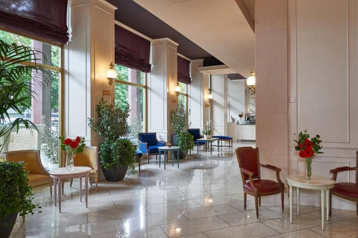 A spacious lobby with a polished floor, comfortable seating areas, and large windows allowing natural light.