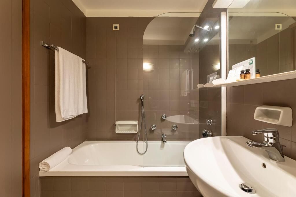 Ein modernes Badezimmer mit Badewanne, Waschbecken und Spiegel.