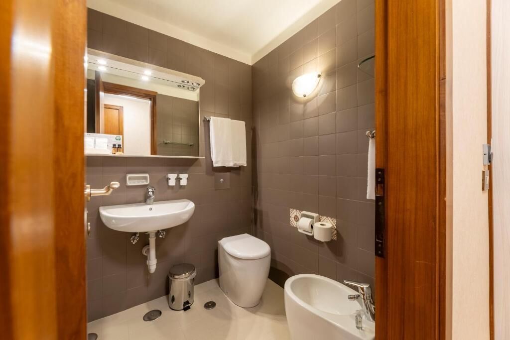A modern bathroom with a white sink, toilet, and bathtub.