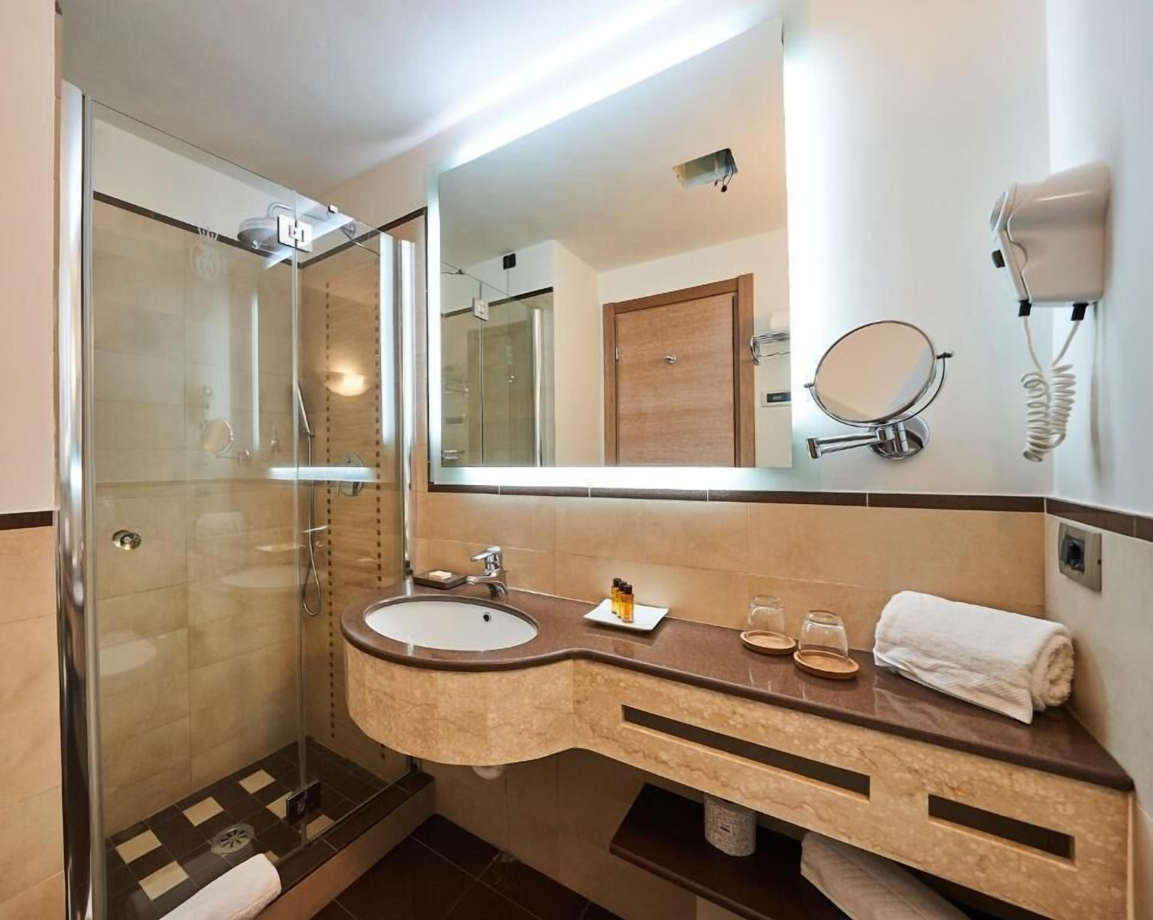 Een aparte badkuip en douche, een haardroger, pantoffels, handdoeken