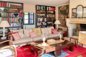 Una sala de estar acogedora con un sofá, una mesita de centro y estanterías llenas de libros.