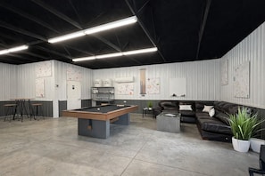 A billiards room with a pool table, stools, a sofa, and a coffee table. - The Hummingbird Yurt: Unique Hocking Hills Stay w/ Hot Tub, Fire Pit + Game Barn (Logan)
