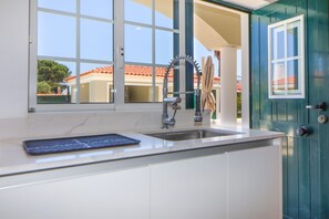 A kitchen with a sink, a window, and a door. - Villa Dos Amores - Heated swimming pool (Azeitão)