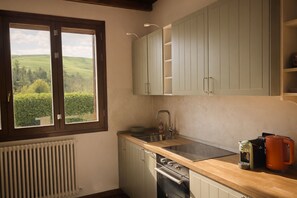 Eine Küche mit Fenster, Spüle, Schränken und Backofen.
