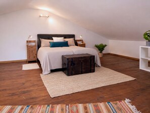 A bedroom with a bed, bedside tables, a suitcase, a plant, and a patterned rug. - Dolce Collina Holiday Home,
Sunset terrace & vineyard views, near Bologna/Imola (Dozza)