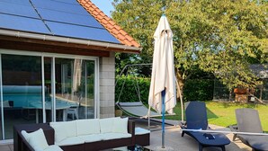 A poolside area with a sun lounger, a swing, and a covered seating area. - Appt, with private outdoor space with barbecue, swimming pool (Aigueperse)