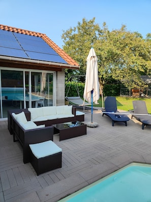A poolside area with a sun lounger, a swing, and a covered seating area. - Appt, with private outdoor space with barbecue, swimming pool (Aigueperse)