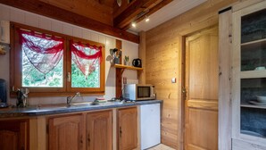 Une cuisine avec des meubles de rangement en bois, un four à micro-ondes et un évier.
