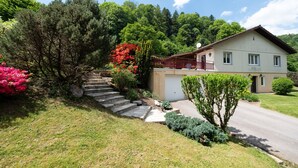 Une maison à deux étages avec un porche à l’avant, un garage et une allée.