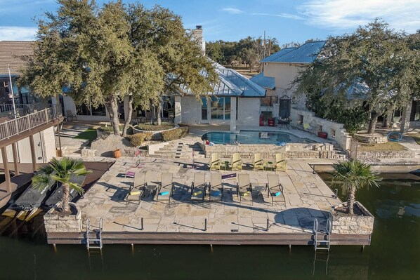 A pool area with lounge chairs, a small pool, and a building with a blue roof.