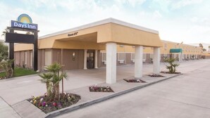 Ein Days Inn Hotel mit schlichtem, zweckmäßigem Design, das einen zentralen Eingang und einen überdachten Außenbereich bietet.