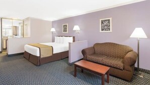 Ein Hotelzimmer mit Bett, Sofa, kleinem Tisch und zwei Wandleuchten.