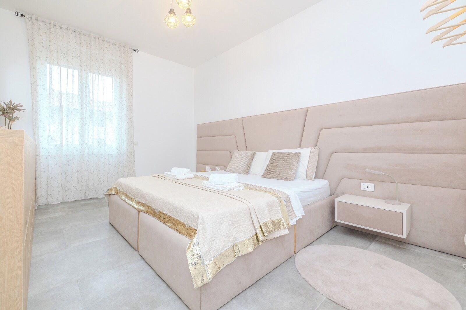 Una camera da letto moderna con un letto grande, comodini e un tavolino da notte.