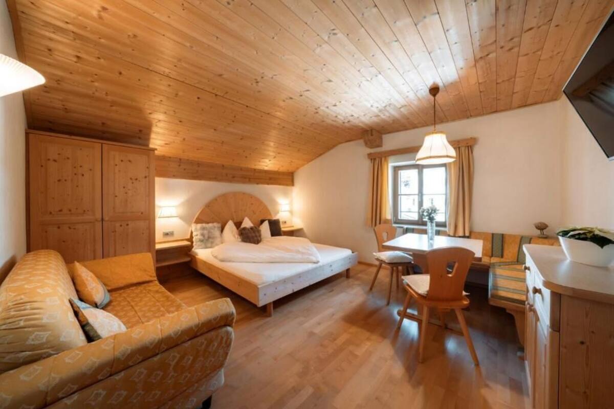 Une pièce confortable avec un lit, un canapé, un bureau et une chaise.