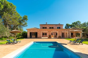 A two-story house with a swimming pool, outdoor furniture, and a patio area. - Exclusive Villa in Mallorca for 12 Guests: Pool, Garden & Jacuzzi (Illes Balears)