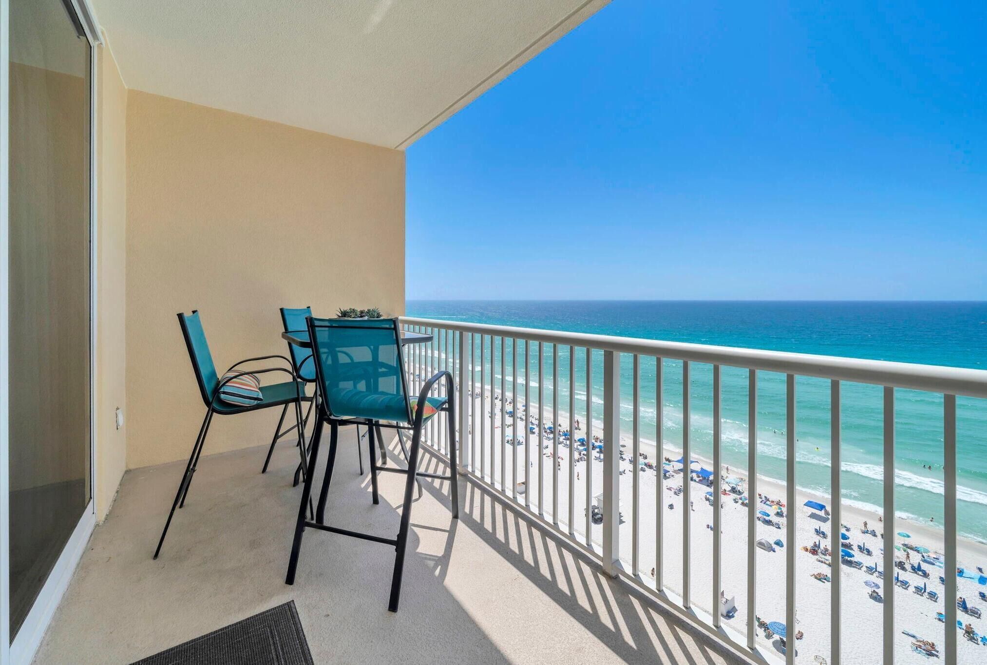 A balcony with a view of the beach and ocean.