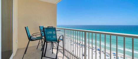 A balcony with a view of the beach and ocean.