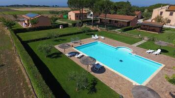 Una piscina al aire libre de temporada, sombrillas