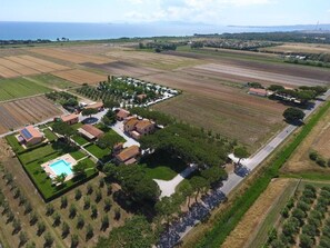 Vista aèria d'una zona residencial amb cases, una piscina i camps de conreu.
