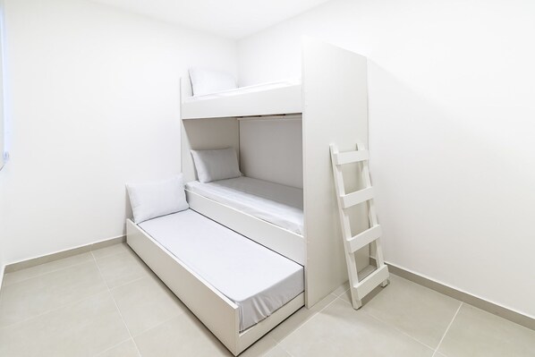 A white bunk bed with a ladder, a small window, and a tiled floor. - APTO Próximo à Praia | Varanda Gourmet | Climatizado | San Martin | Destino BSM 203A (Barra de São Miguel)