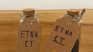Deux bouteilles en verre, fermées par des bouchons en liège, chacune portant une étiquette avec l’inscription « ETNA CI » et un cœur découpé.