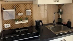 Une cuisine équipée d’un four à micro-ondes, d’une cuisinière, d’un évier et de placards.