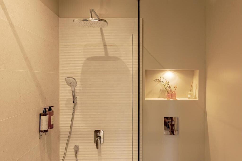 Ein modernes Badezimmer mit Dusche, Handtuchhalter und einer kleinen Ablage mit Dekoration.