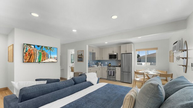 Une chambre d’hôtel moderne dotée d’un grand lit, d’une kitchenette, d’un coin repas et offrant une vue sur l’extérieur.