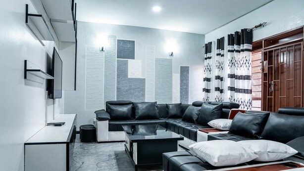 Una sala de estar moderna con un sofá modular, una mesa de centro y un televisor instalado en la pared.