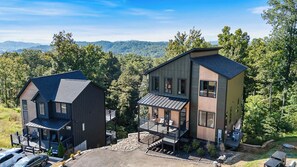 Ein modernes, zweistöckiges Gebäude mit Balkon und Carport.