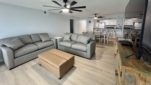 A modern living room with a grey sofa, a wooden coffee table, and a ceiling fan. - Breakers C52 - Direct Gulf Front (Orange Beach)