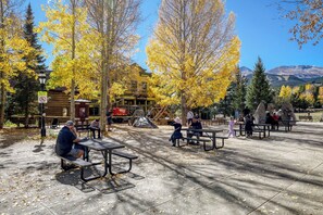 A park with picnic tables, benches, and people. - Powder Ridge 208  - close to lifts and town! (Breckenridge)