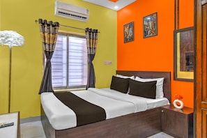 A hotel room with a bed, curtains, an air conditioner, and two paintings on the wall. - Classic The Avenue Inn (Bidhannagar)