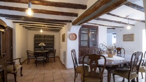 Un coin repas comprenant une table et des chaises en bois, un meuble à vin et un buffet aux portes vitrées.