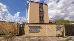 A beige multi-story building with a gated entrance, solar panels, and a series of electrical boxes on the facade. - Apartments in Jd. Centenario in Pocos de Caldas - Clds (Poços de Caldas)