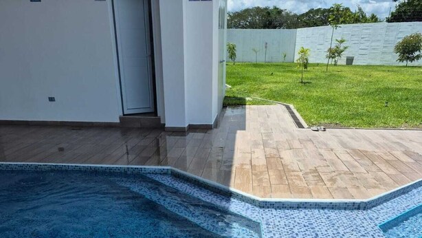 A swimming pool with a mosaic tile edge, surrounded by a wooden deck and a white wall. - "Casa Mia" in San Miguel with all the amenities for a peaceful and pleasant stay (San Miguel)
