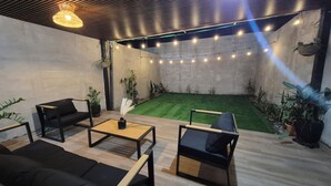 A modern outdoor seating area with a wooden floor, black furniture, and string lights. - "Casa Mia" in San Miguel with all the amenities for a peaceful and pleasant stay (San Miguel)