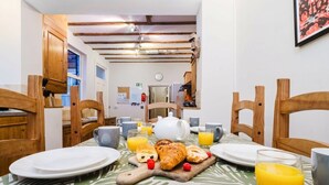 Ein Frühstückstisch für zwei Personen, gedeckt mit Croissants, Orangensaft und einer Teekanne.
