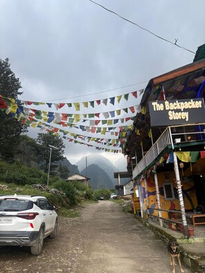 Une boutique appelée « The Backpacker Storey » avec des guirlandes de drapeaux de prières colorées suspendues au-dessus de l’entrée.