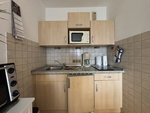 Eine kleine Küche mit Mikrowelle, Kaffeemaschine und Toaster.