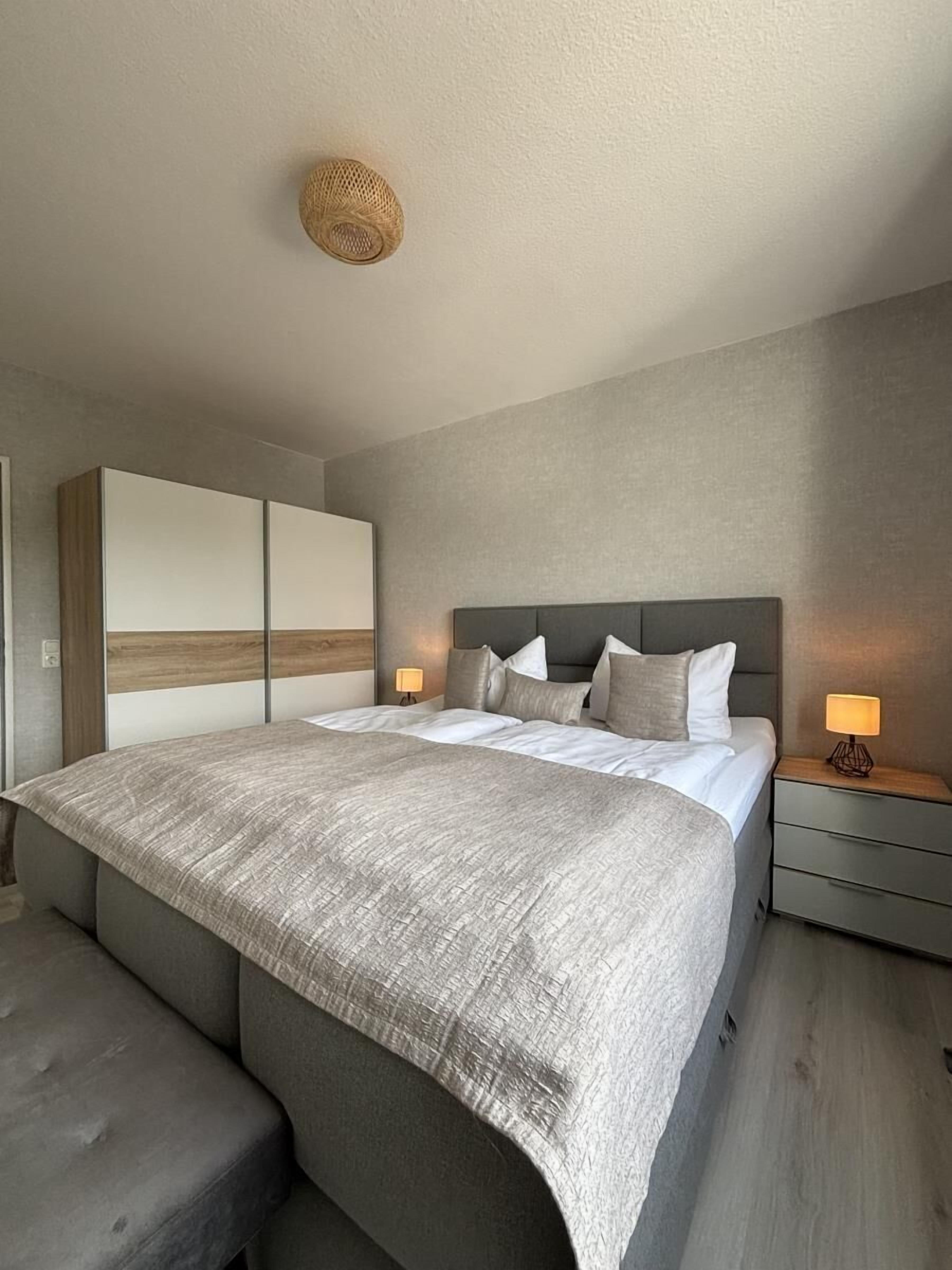 Ein modernes Schlafzimmer mit einem großen Bett, Nachttischen und einem Kopfteil.